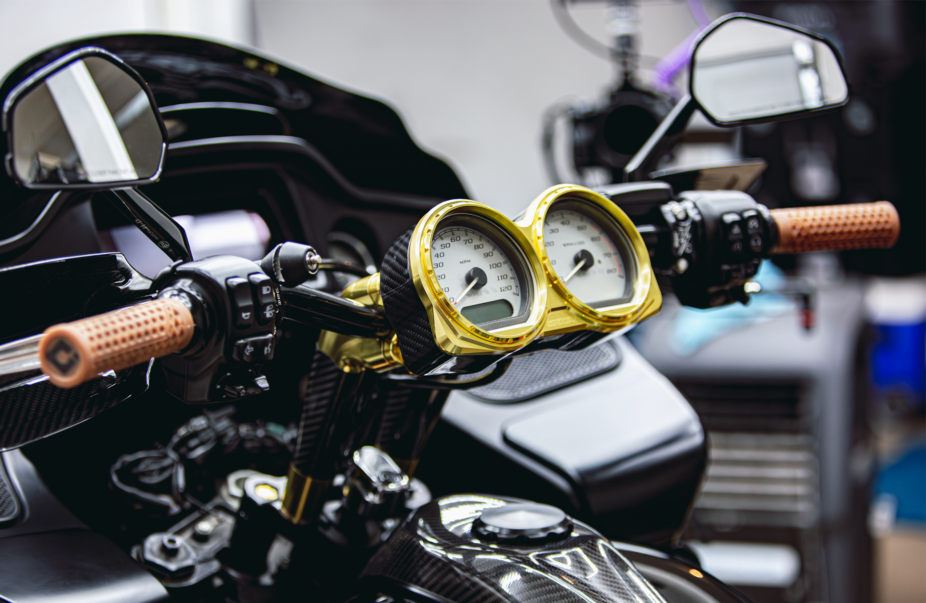 Photo by Anthony Mojica. RF7 Carbon Fiber Dual Gauge Bezel shown with light gold gauge rings. Gauges are not included; designed to work with stock gauges on 2014-2023 Road Glide models.