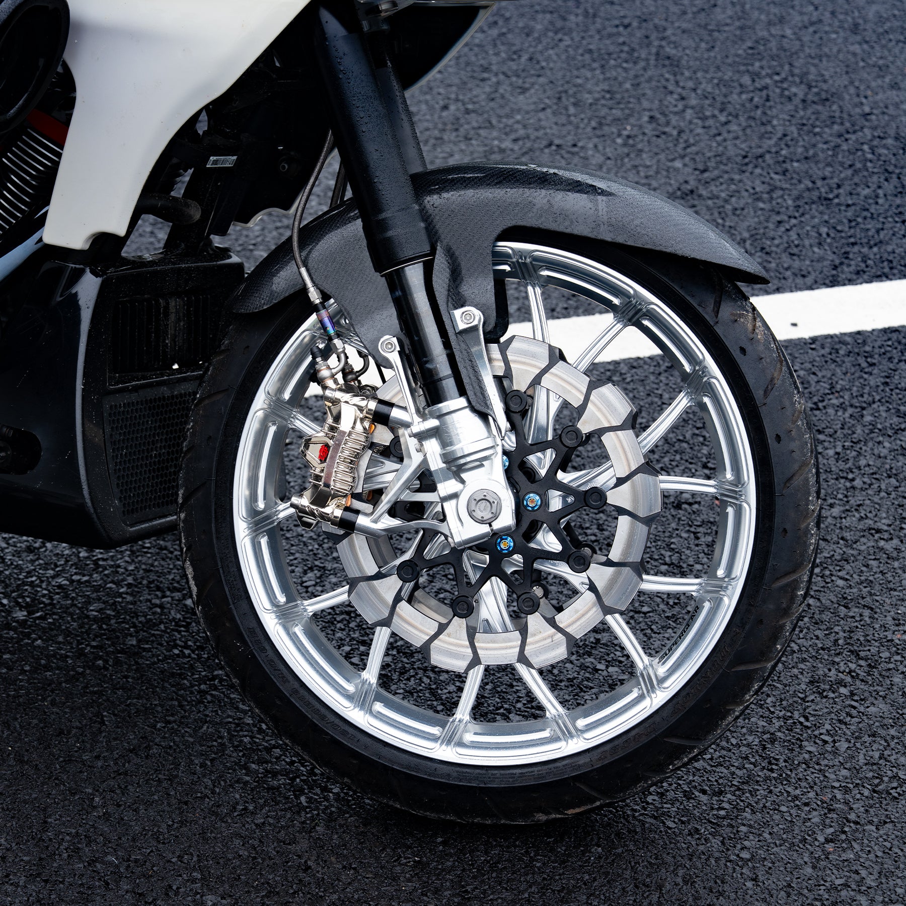 24+ road glide cvo st forged front wheel setup with a machined wheel hub and performance brake rotors.