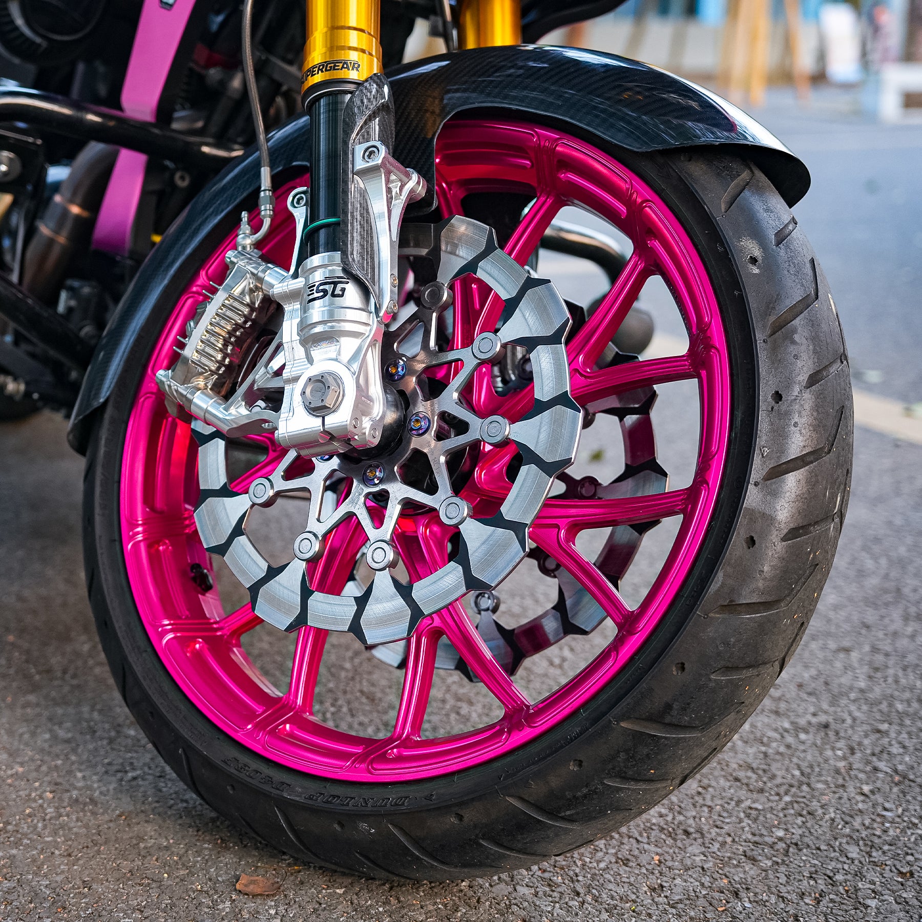 Close-up of a Y-Spoke forged front wheel and dual brake rotors installed on a customized Harley-Davidson Touring motorcycle