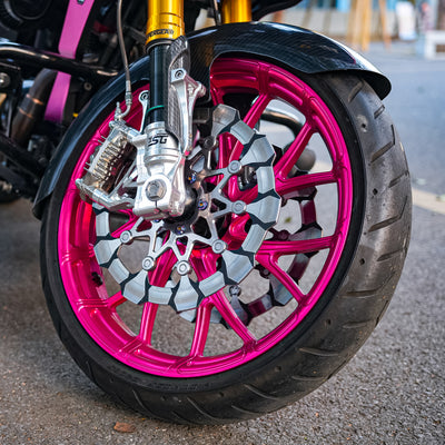 Close-up of a Y-Spoke forged front wheel and dual brake rotors installed on a customized Harley-Davidson Touring motorcycle